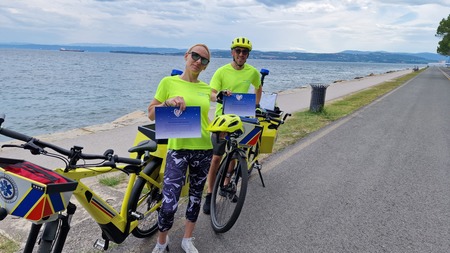 Reševalca na kolesih na obalni cesti z ustreznim certifikatom v rokah